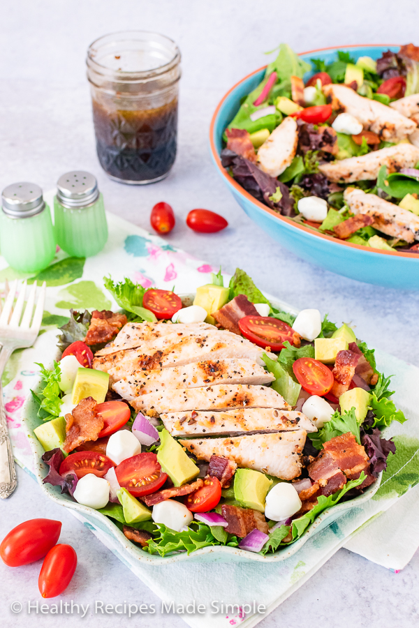 Small salad bowl with grilled chicken and vegetables on a bed of spring mix.
