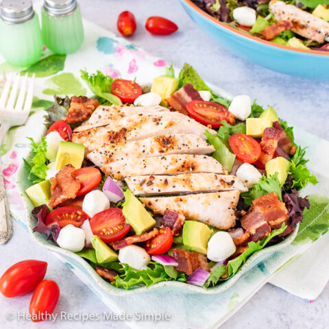 Grilled chicken breast layered on a bed of spring mix and vegetables.