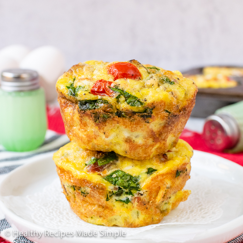 Square picture of 2 baked keto egg muffin cups on a plate.