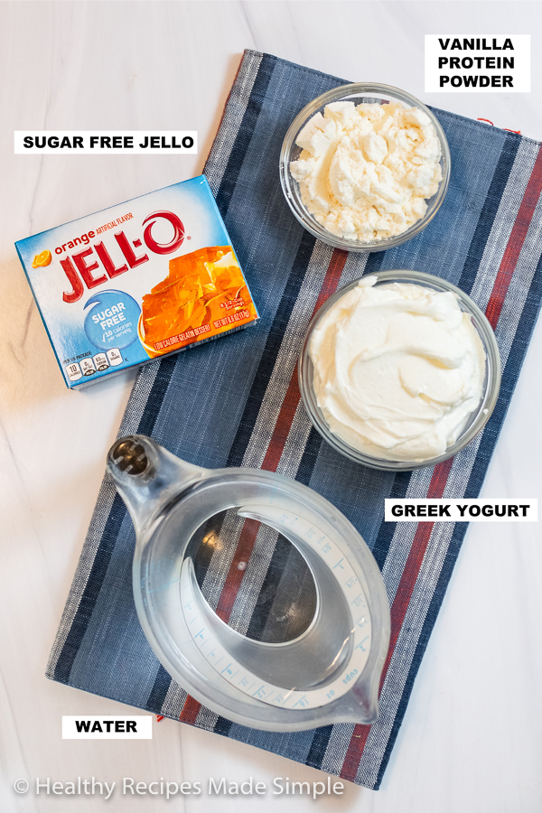 Overhead shot of sugar free jello, water, protein powder, and greek yogurt.