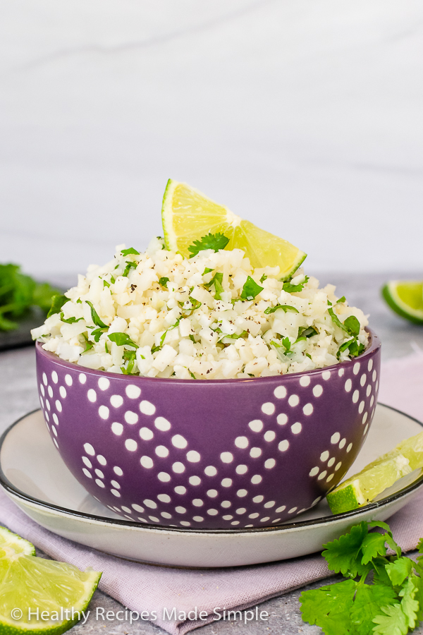 A close up picture of a purple bowl full of Cilantro Lime Cauliflower Rice.