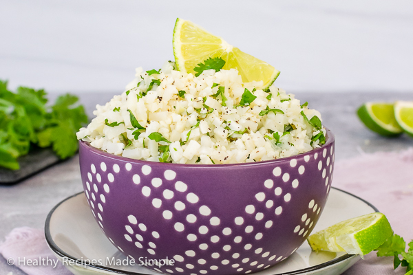 Rectangle picture of a purple bowl full of Cilantro Lime Cauliflower Rice.