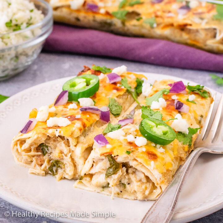 2 salsa verde chicken enchiladas on a white plate.