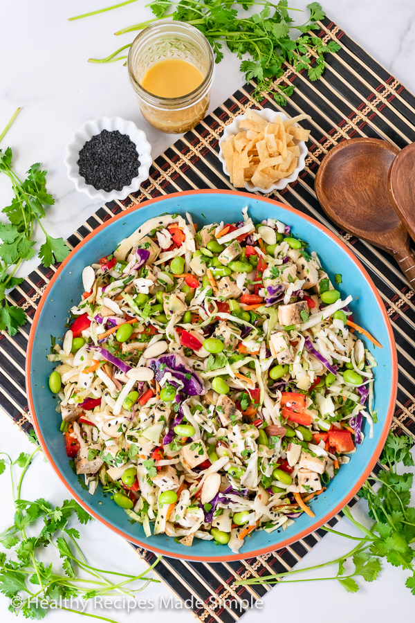 Overhead picture of a blue bowl filled with a cabbage salad with chicken.