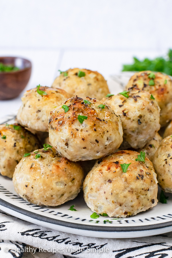 A close up picture of meatballs on a white plate.