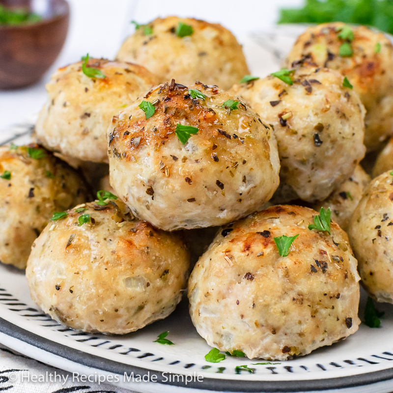 Square picture of chicken meatballs on a white plate.