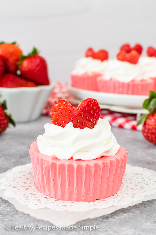 A creamy pink yogurt bite topped with whipped topping and a strawberry heart.
