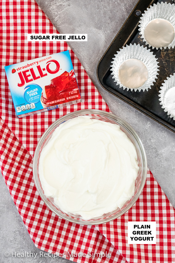A picture of greek yogurt in a bowl with a box of strawberry jello.