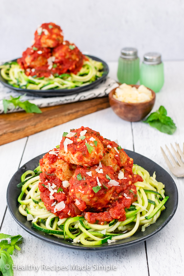 Chicken meatballs in red sauce on green Zucchini noodles.