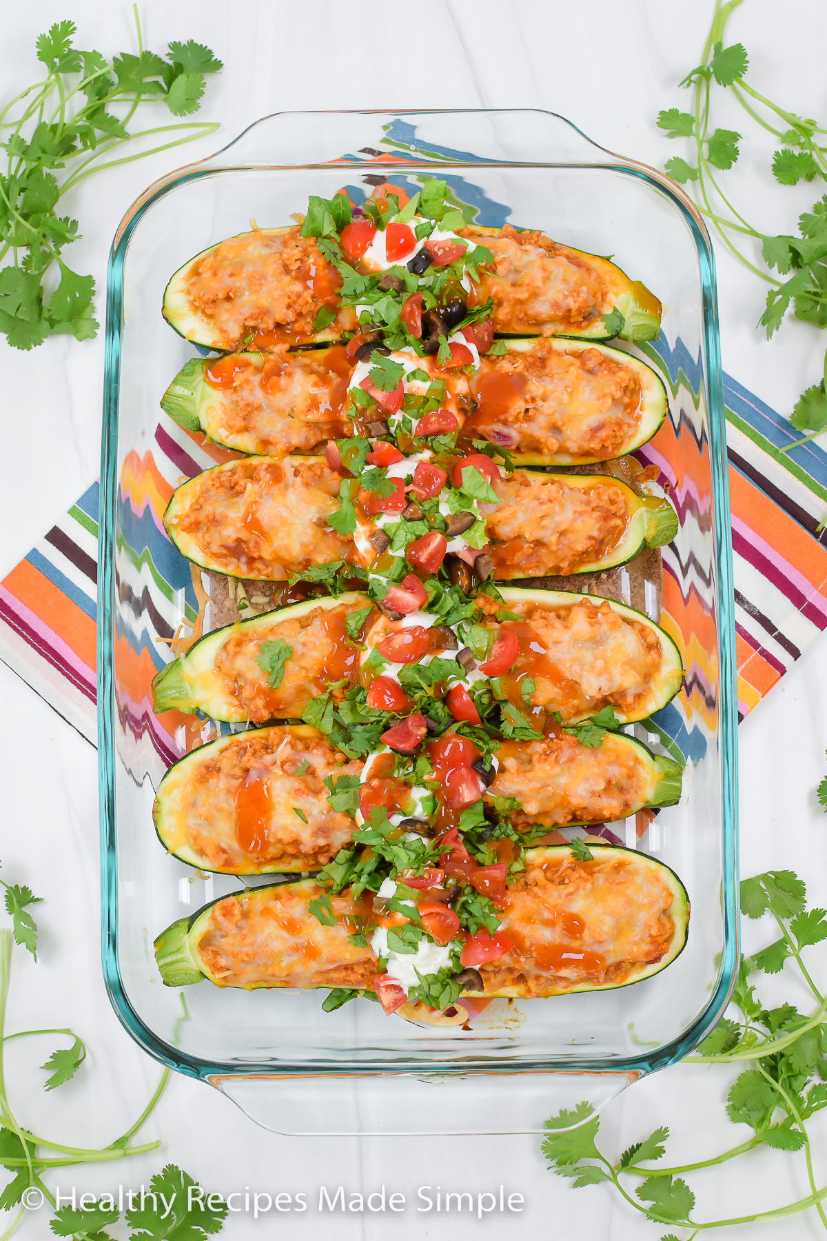 An overhead picture of 6 taco stuffed zucchinis in a 9x13 pan.