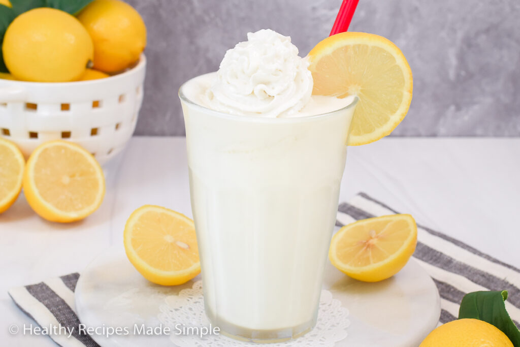 Lemonade shake surrounded by lemons.