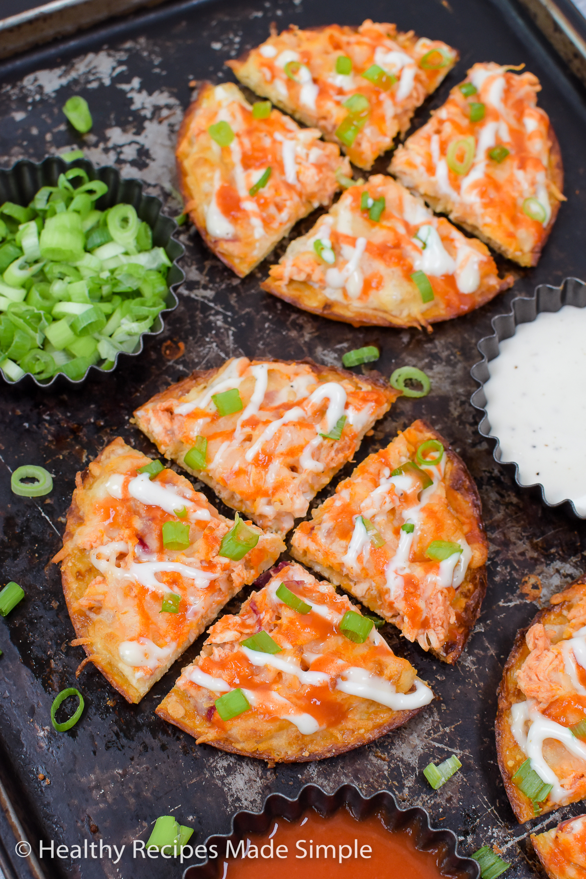 Mini buffalo chicken pizza topped with ranch and green onion.