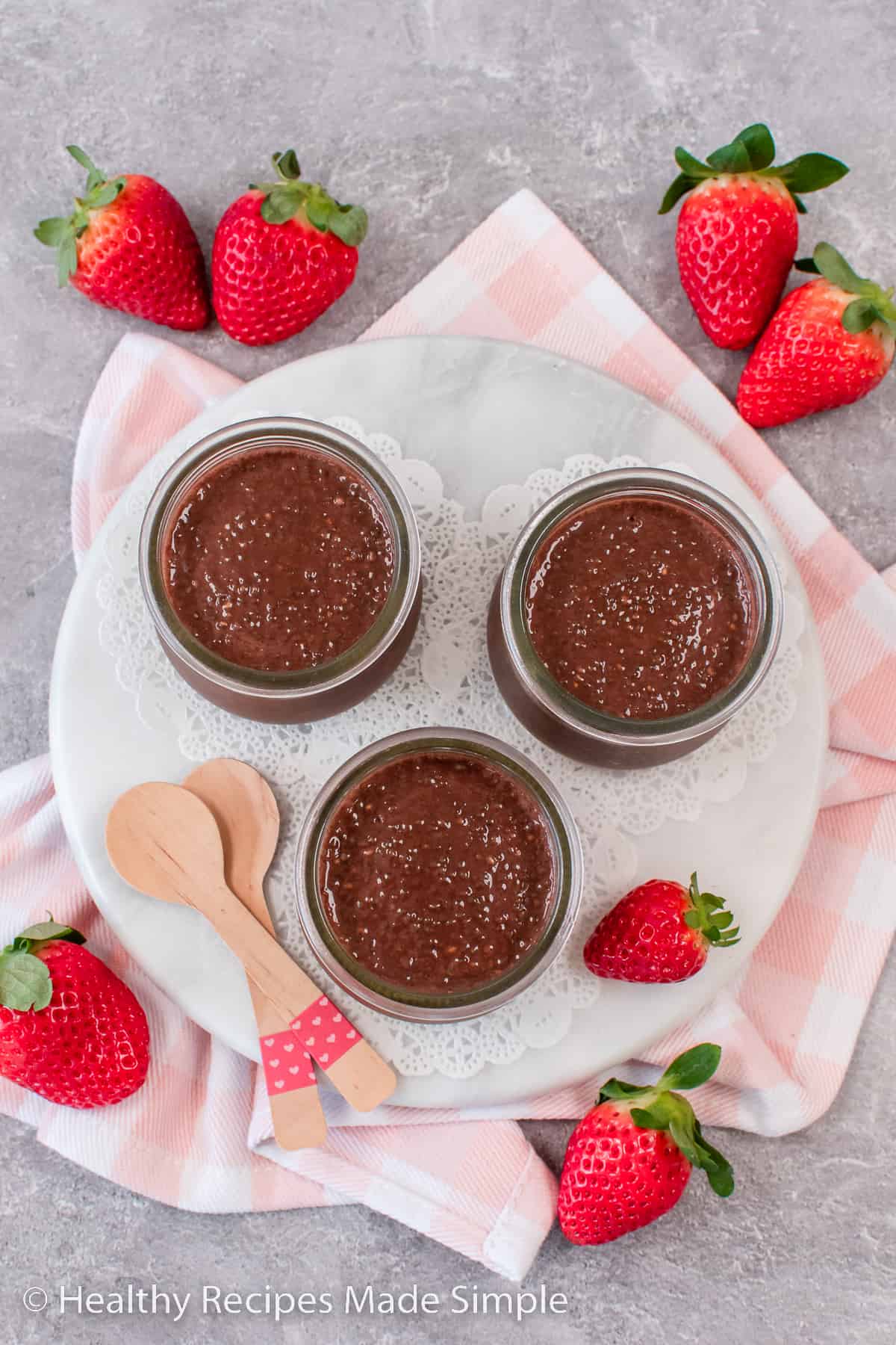 An overhead picture of 3 jars of chocolate chia pudding.