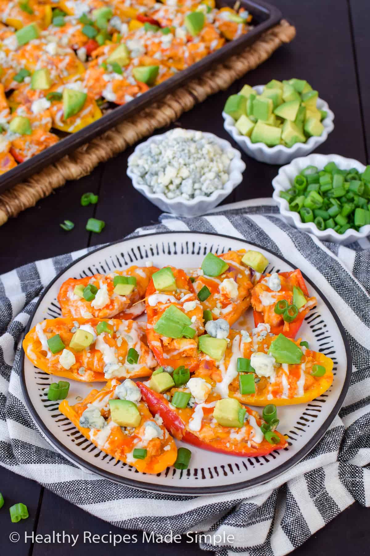 A plate with 8 peppers topped with buffalo chicken and cheese.
