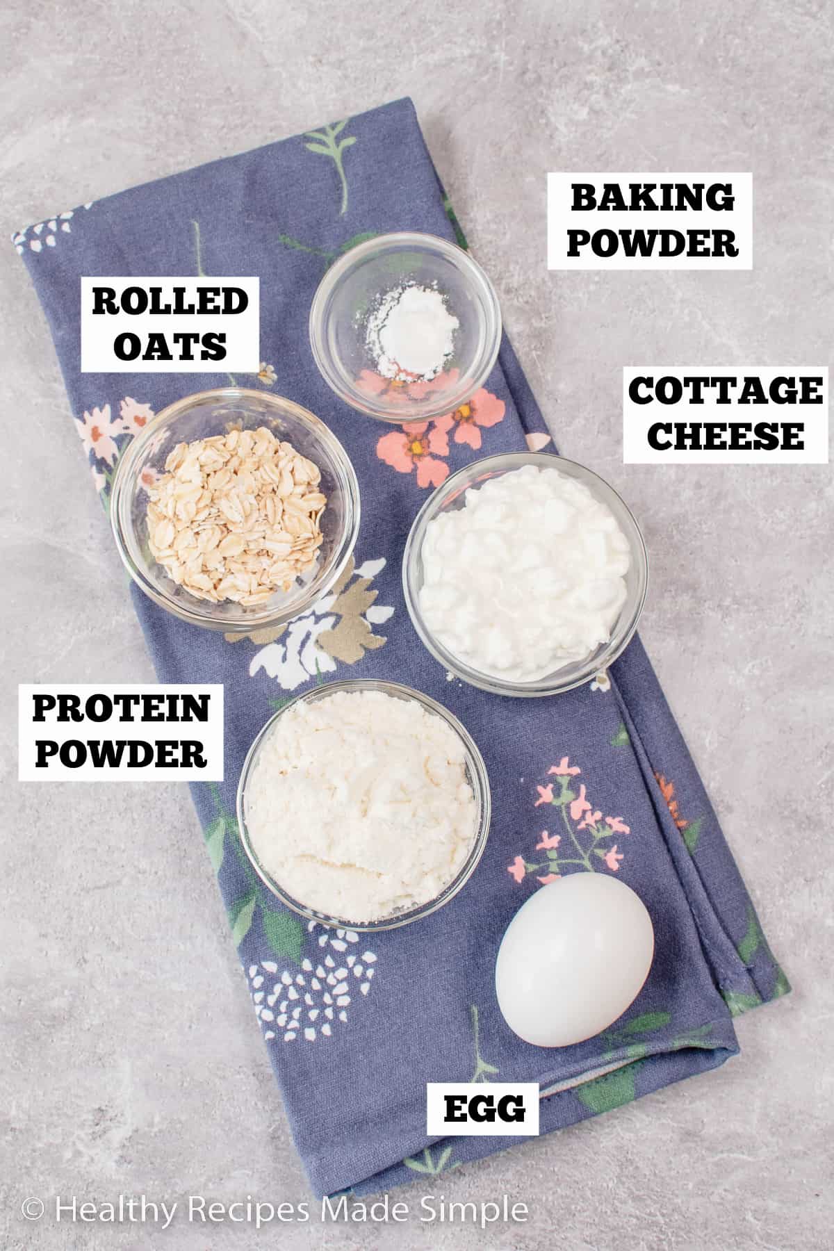 A gray board with bowls of ingredients needed to make protein waffles.