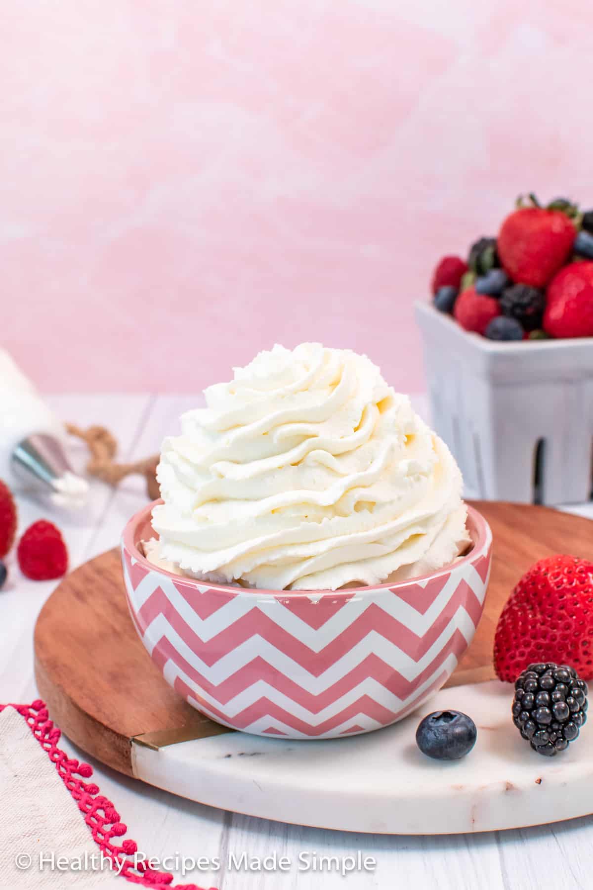 A bowl of no sugar whipped cream in a pink and white bowl.