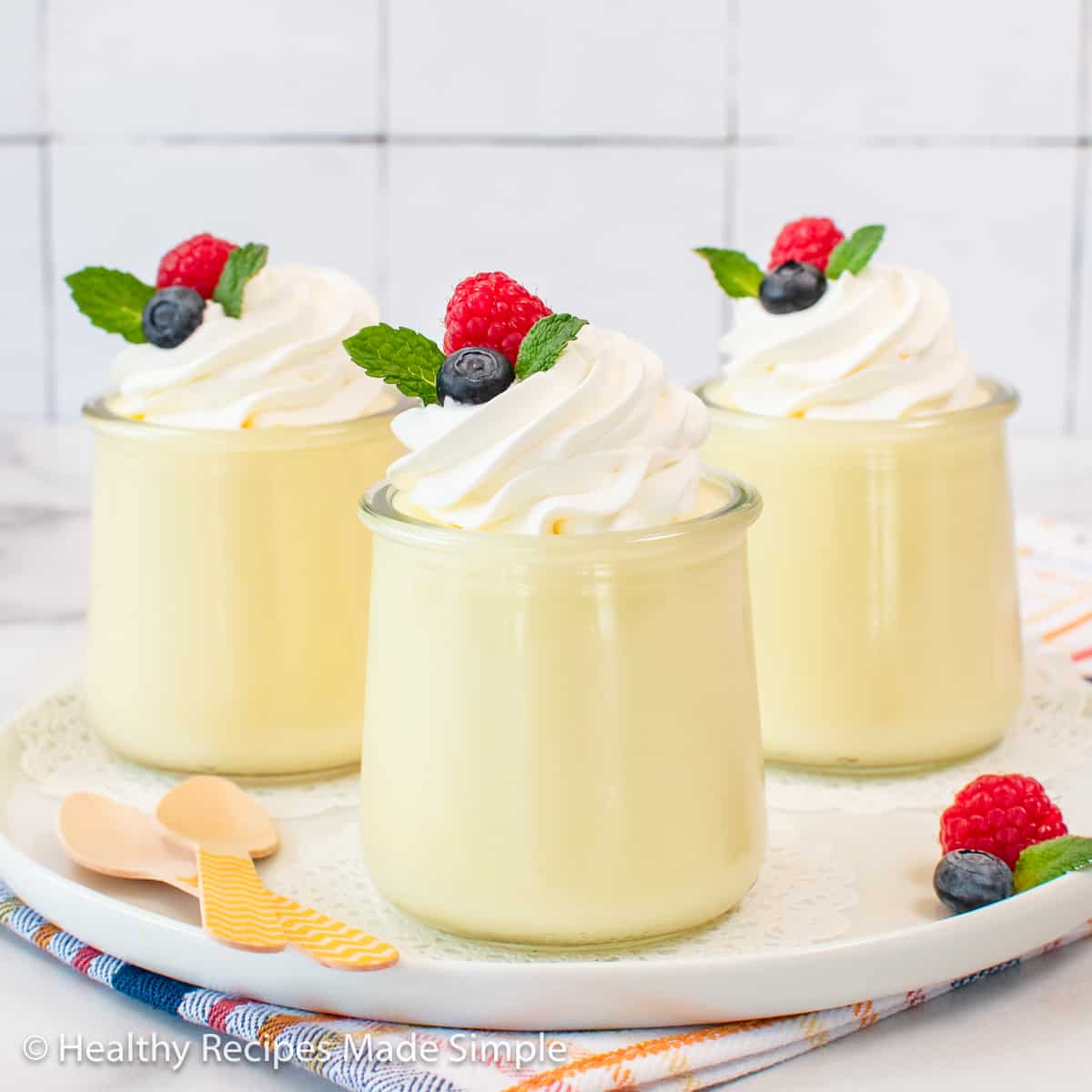 Three little jars filled with creamy lemon jello.