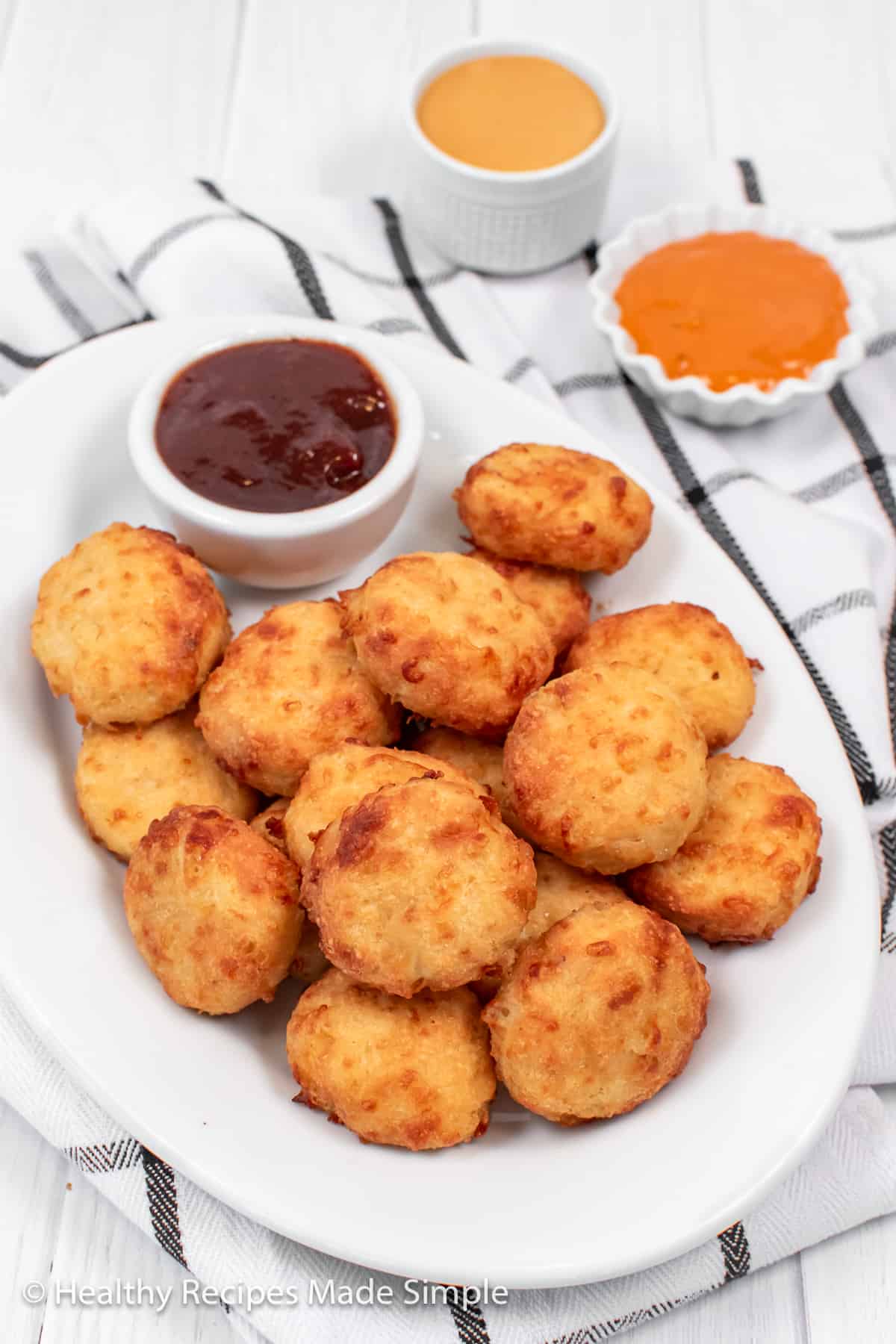 Chicken nuggets on a white plate.
