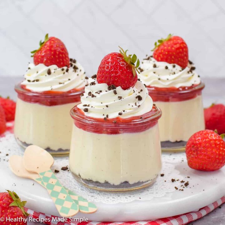 Three parfait cups filled with pudding and whipped cream.