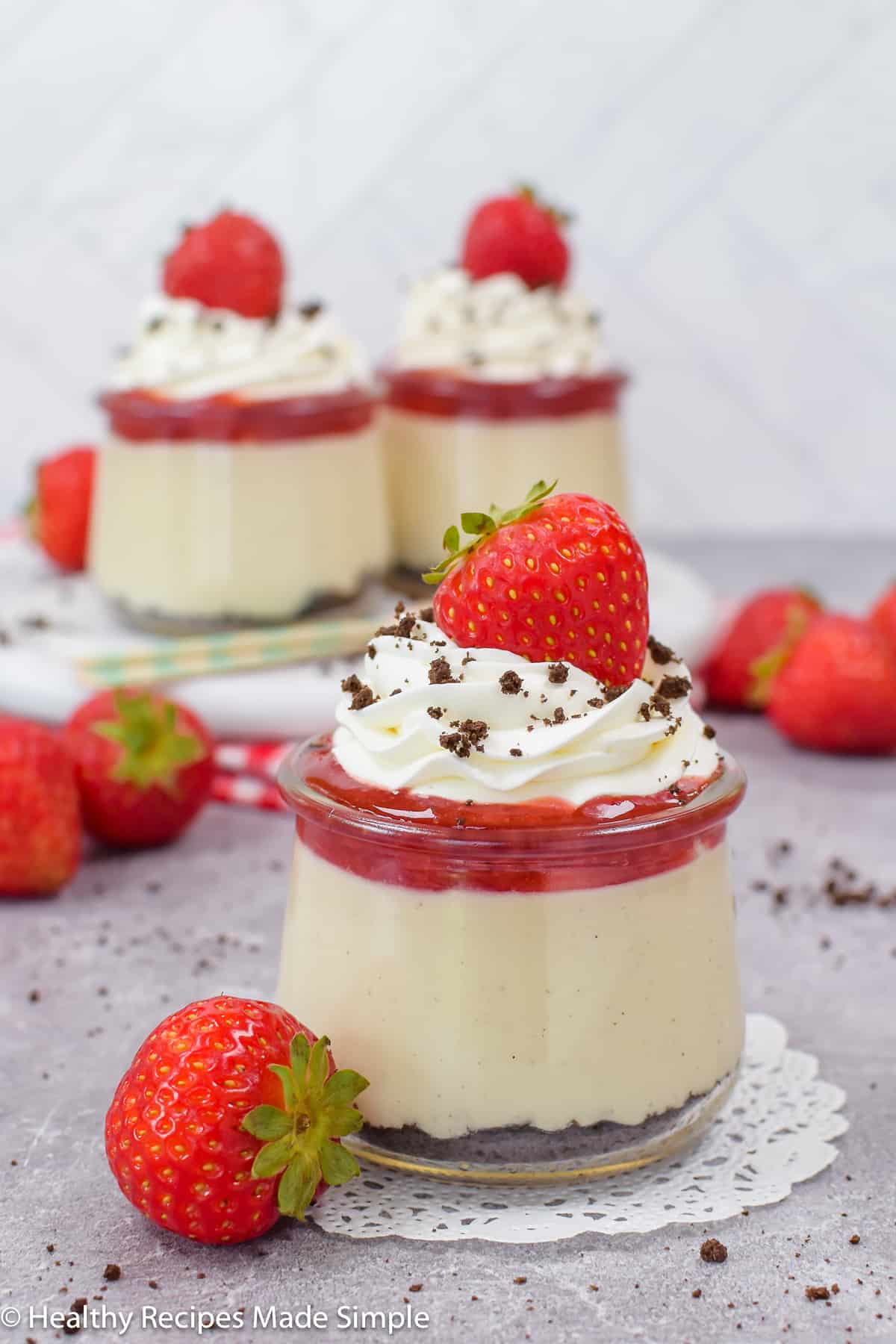 White chocolate pudding cups topped with berries and whipped cream.