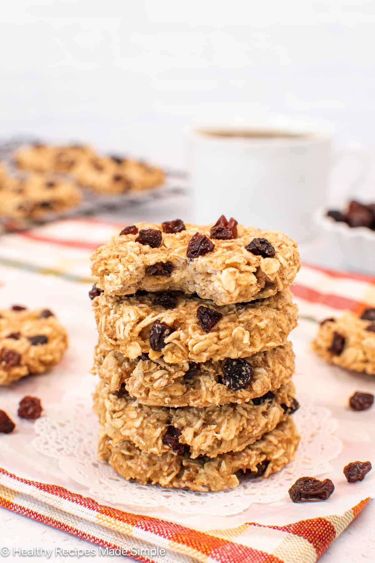 A stack of oatmeal raisin cookies on a white paper.