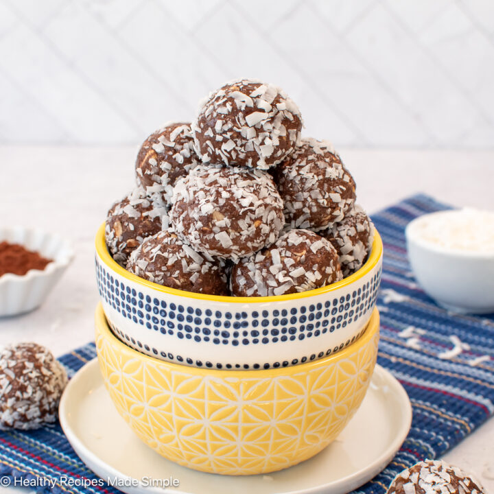 A bowl filled with chocolate protein balls rolled in coconut.