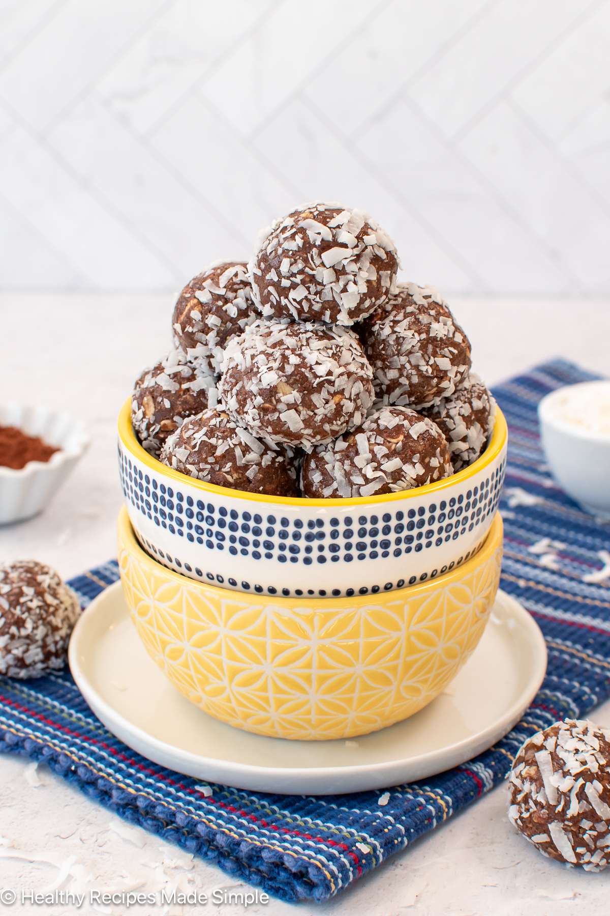 A bowl filled with chocolate protein balls rolled in coconut.