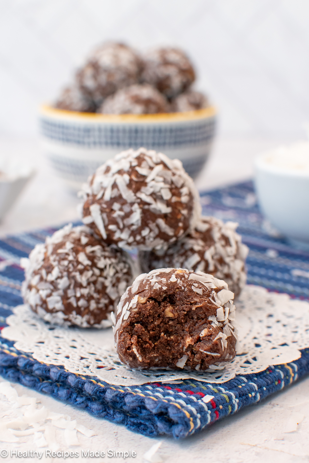 Chocolate coconut balls with a bite out of one of them.